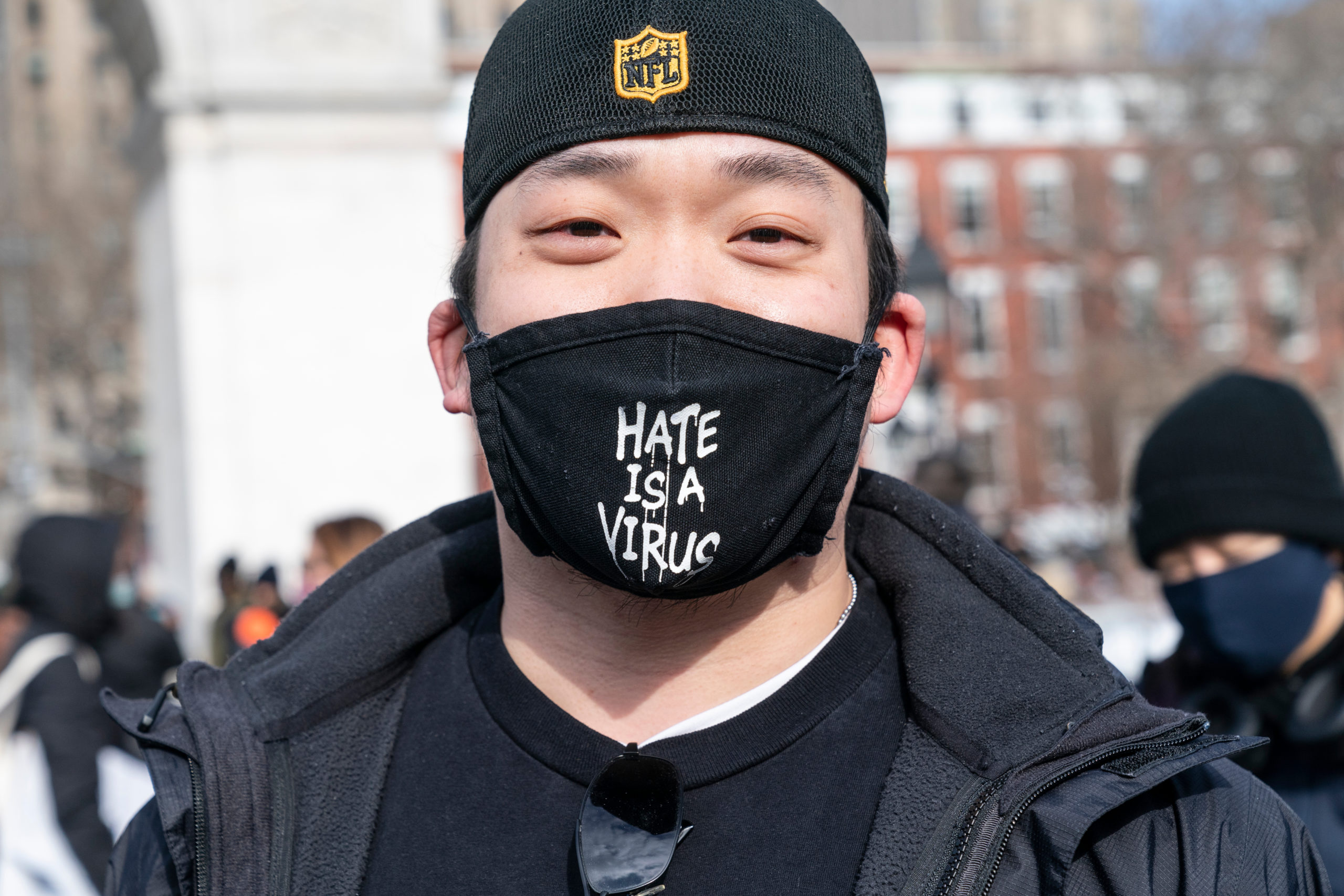 Man wearing face mask emblazoned with "Hate is a Virus"